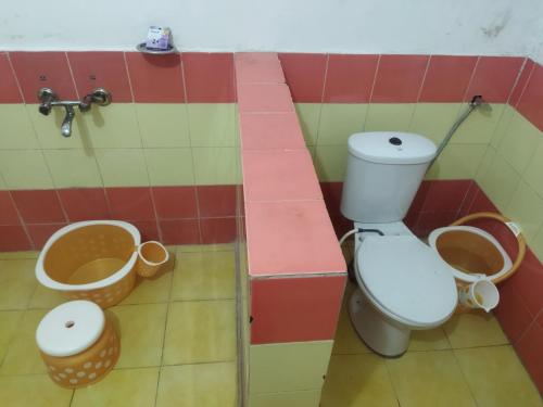 La salle de bains est pourvue de toilettes et de 2 paniers. dans l'établissement Samarpan stay, à Nainital