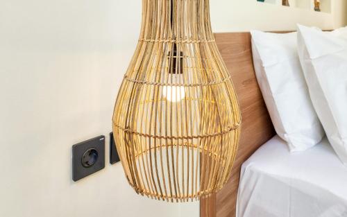 a rattan hanging light next to a bed at Dandelion Villas Pandawa by Nagisa Bali in Badung