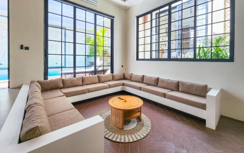 a living room with a large couch and a table at Dandelion Villas Pandawa by Nagisa Bali in Badung