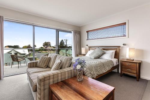 a living room with a couch and a bed at Captain's at the Bay in Apollo Bay