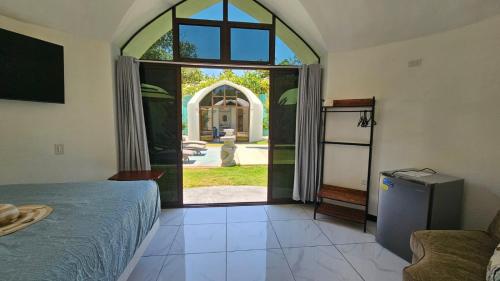 sypialnia z łóżkiem i dużymi szklanymi drzwiami w obiekcie Alborada Boutique Stay w mieście Uvita