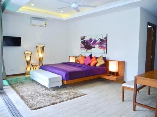 een slaapkamer met een paars bed en een bureau bij Rawai Beach Private Pool Villa -3 Bedrooms in Rawai Beach