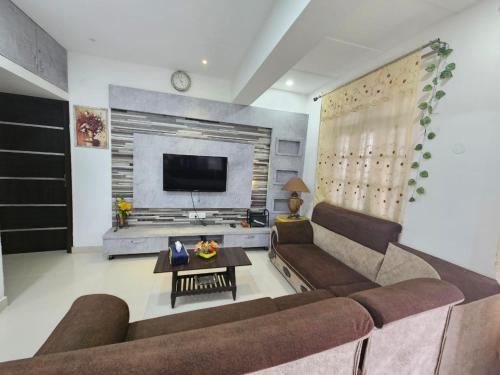 a living room with a couch and a tv at Stylish Penthouse Apartment - ATITHI ESTATE in Hyderabad