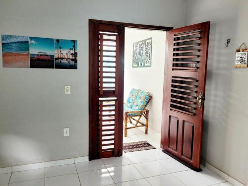 a room with a door and a chair next to a wall at Casa Centro de Jijoca in Jijoca de Jericoacoara