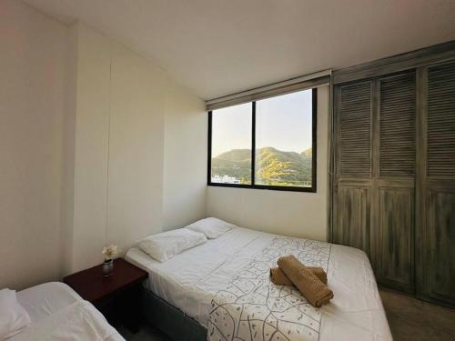 a small bedroom with a bed and a window at Acogedor apartamento Rodadero Santa Marta con vista al Lago in Santa Marta