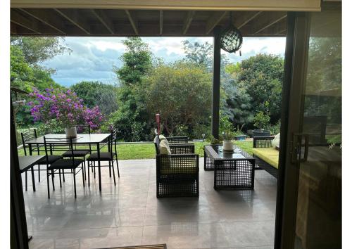 a patio with a table and chairs and a clock at Quiet haven in Forster