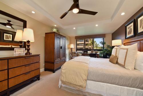 a bedroom with a large bed and a dresser with a ceiling fan at Kaanapali Alii 456 in Kaanapali