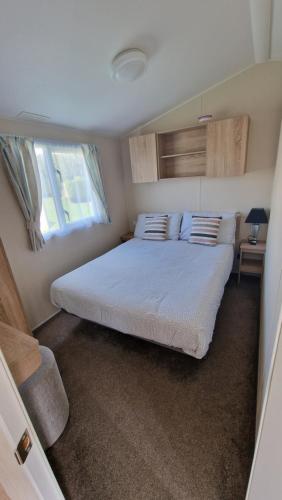 a bedroom with a bed in a small room at Cosy caravans 10 berth caravan on Butlins Skegness in Skegness