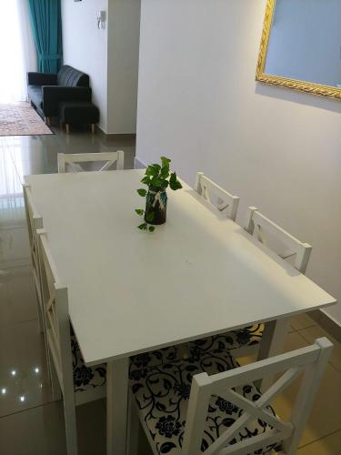 a white table and chairs with a potted plant on it at Homestay King Putrajaya sebelah Alamanda in Putrajaya