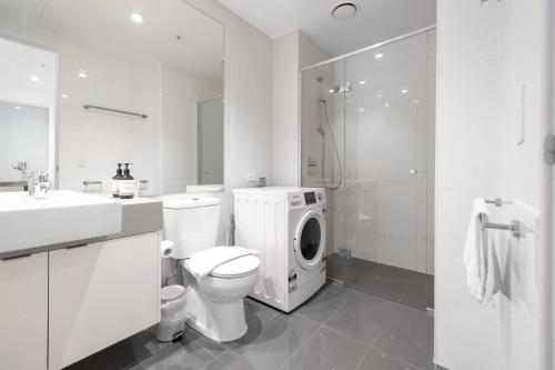 a bathroom with a toilet and a washing machine at Light Filled 2br Southbank Parking Pool in Melbourne