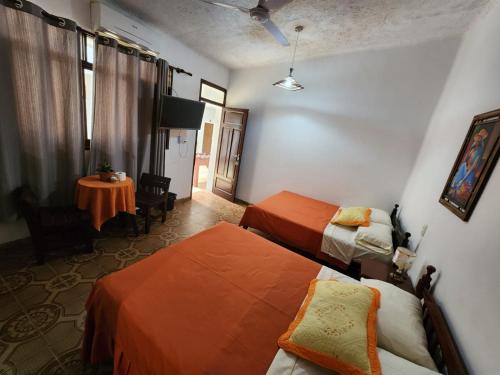 a hotel room with two beds and a table at HOSTAL BOLIVIA EN YACUIBA in Yacuiba