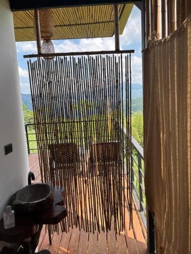 a room with a balcony with a chair and a window at Romantic Glamping for 2 in the Mountain Access with 4x4 or motorbike only in Villeta