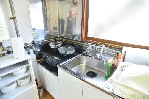 a small kitchen with a sink and a stove at Greenheim Suitengushita / Vacation STAY 1689 in Otaru