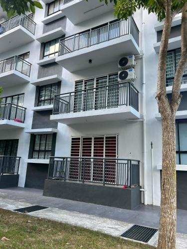 a white apartment building with balconies and a tree at AARON MARUDU HOMESTAY in Kampong Sorosob