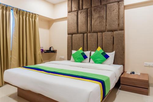a bedroom with a large bed with a large headboard at Treebo Blossom - Viman Nagar in Pune