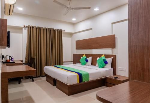 a hotel room with a bed and a desk at Treebo Blossom - Viman Nagar in Pune