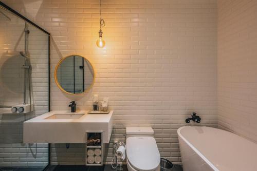 a bathroom with a sink and a toilet and a tub at Gwangju Hotel the spot in Gwangju