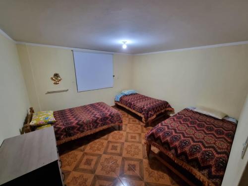 Zimmer mit 2 Betten und einer Leinwand in der Unterkunft La Yunza Hogar in Ayacucho
