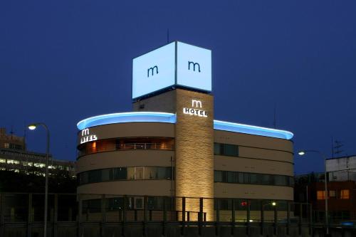 a building with a sign on the top of it at HOTEL ｍ in Matsudo