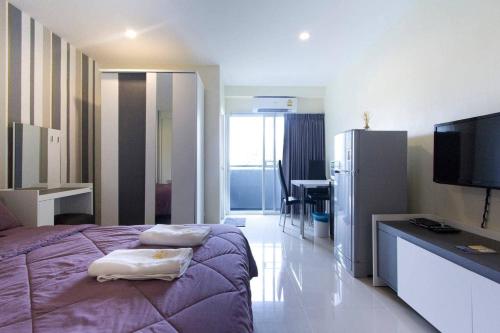 a bedroom with a purple bed and a refrigerator at The Arni Sukhumvit 101 in Bangkok