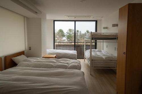 Katsuno的住宿－Biwako Galaxy，客房设有三张双层床和一扇窗户。