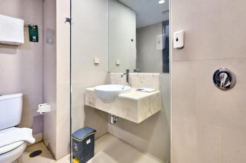 a bathroom with a sink and a toilet at Grand Orchid Hotel Yogyakarta in Yogyakarta