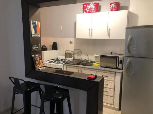 a kitchen with a counter with a microwave and a refrigerator at Departamento 3 ambientes en Resistencia in Resistencia