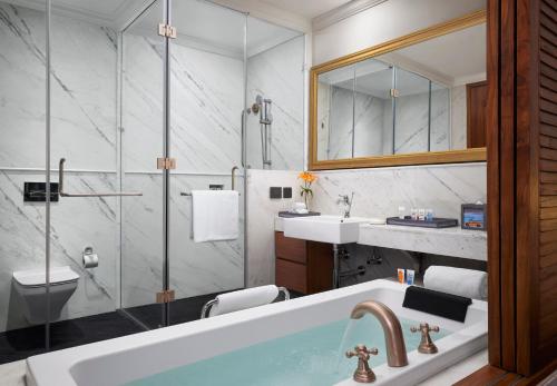 a bathroom with a tub and a sink and a shower at Storii By ITC Hotels Devasom Resort & Spa, Kolkata in Bāruipur