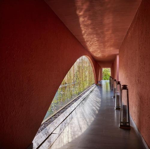 a train station with a red wall and a bridge at Storii By ITC Hotels Devasom Resort & Spa, Kolkata in Bāruipur