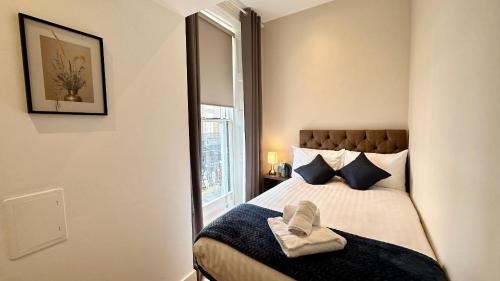 a bedroom with a bed with blue pillows and a mirror at Putera Puteri Residence in London
