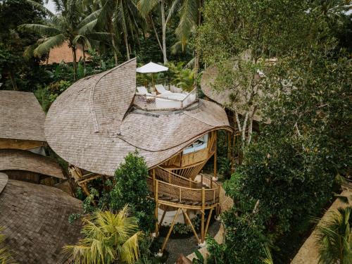 een uitzicht op een huis met een dak bij Bambootel Sawah View in Ubud