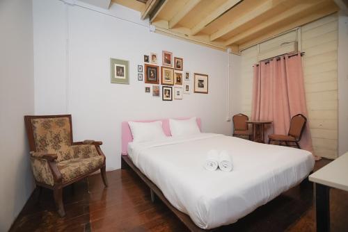 a bedroom with a large white bed and a chair at มิตร อินน์ เยาวราช Mitr Inn Yaowarat in Khlong San
