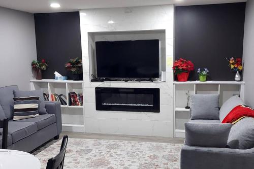 a living room with a flat screen tv on a wall at Cozy 2-Bedroom Basement Guest Suite with Private Entrance and Proximity to the Airport in Edmonton