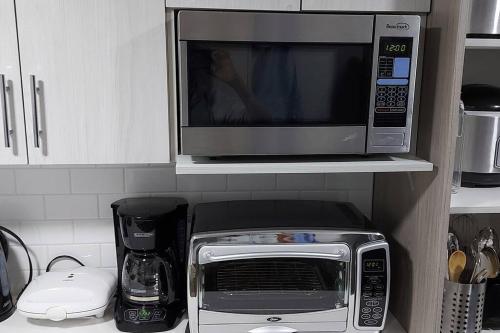 a microwave sitting on top of a kitchen counter at Cozy 2-Bedroom Basement Guest Suite with Private Entrance and Proximity to the Airport in Edmonton