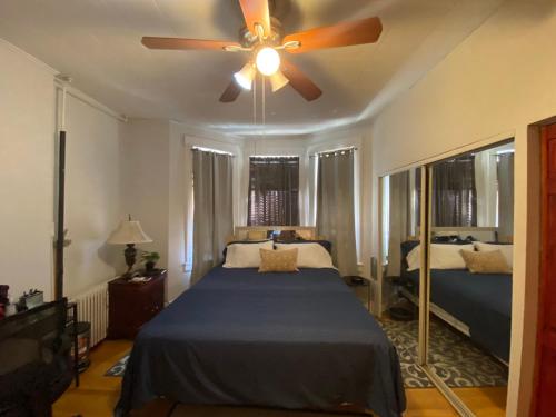 um quarto com uma cama e uma ventoinha de tecto em Harmony place to stay close to all fun in Jersey at 15 minutes to NY City em North Bergen