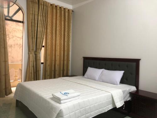 een slaapkamer met een bed met twee handdoeken erop bij Hotel Nam Sơn Tân Dương in Hoàng Mai