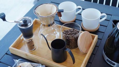 a wooden tray with coffee makers and cups on a table at ポセイドン グランピング Poseidon Glamping in Kujukuri