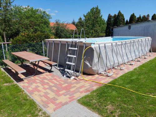 a swimming pool with a table and a ladder next to it at schönes Ferienhaus mit grossem Pool 1200 m zum Balaton in Balatonberény