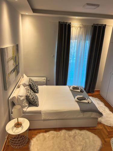 a bedroom with a large bed with a window at Apartman Malena in Trebinje