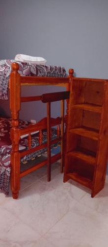 1 dormitorio con cama y estantería de madera en El Quincho T2 en El Carmen