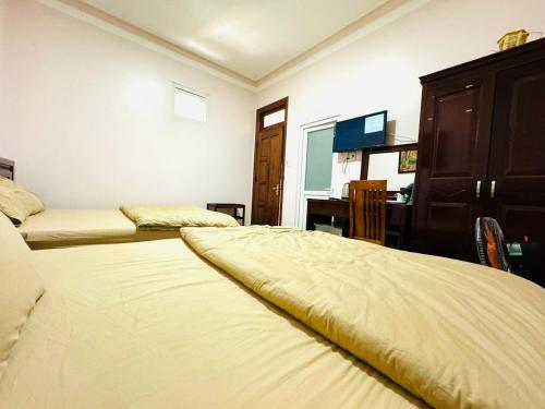 una camera con 2 letti, un comò e una scrivania di Duy Khang Hotel a Da Lat