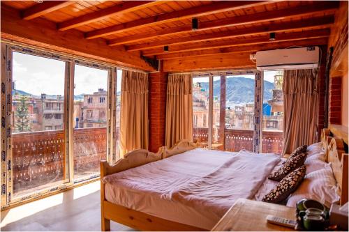 een slaapkamer met een bed in een kamer met ramen bij Nag Pukhu Guest House in Bhaktapur