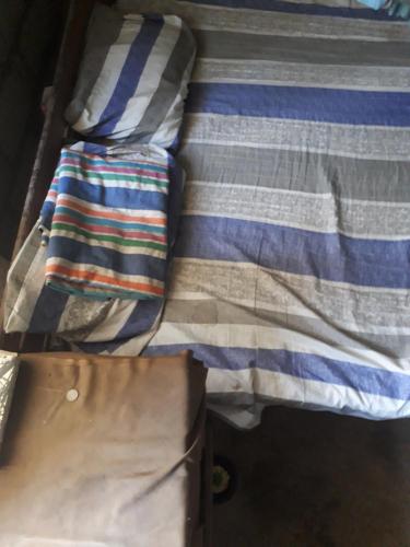 a bed with a striped blanket and a table at Mountain view home stay in Mirigama