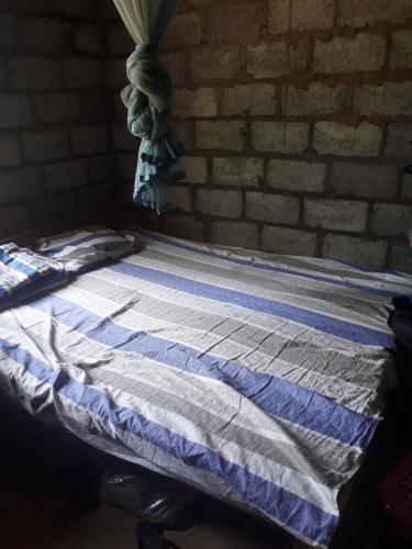 a bed in a room with a brick wall at Mountain view home stay in Mirigama