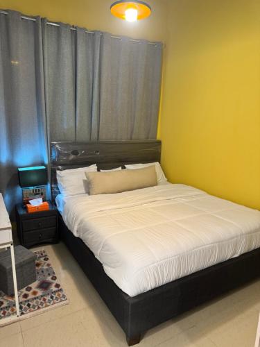 a bedroom with a large bed with a black headboard at شقة سليب تايم in Al Ain