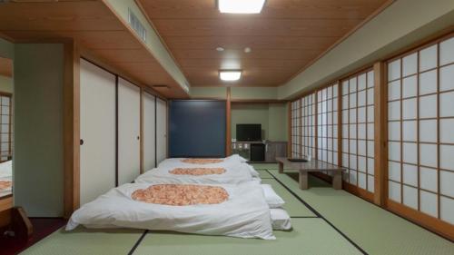 fila de camas en una habitación con ventanas en Onomichi Royal Hotel, en Onomichi