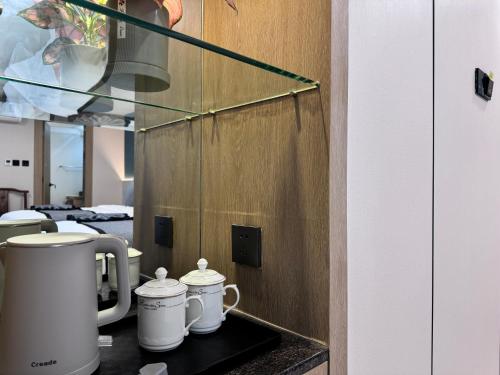 a counter with three white coffee mugs on it at Yixuan Yasi Apartment-free shuttle during the Canton Fari in Guangzhou
