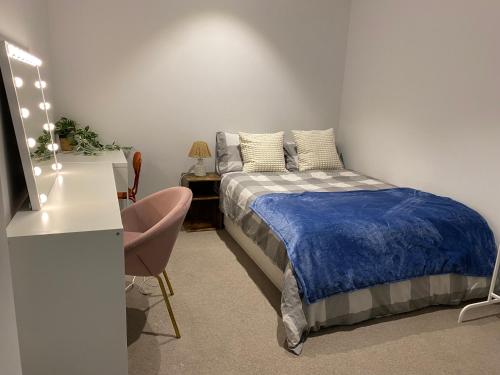 a bedroom with a bed and a desk with a lamp at Darling Harbour 2b apt Car space upon request ICC CBD family friendly with view in Sydney