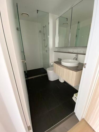 a bathroom with a toilet and a sink and a mirror at Darling Harbour 2b apt Car space upon request ICC CBD family friendly with view in Sydney