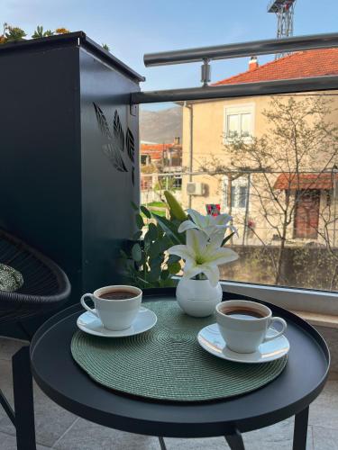 two cups of coffee on a table on a balcony at Apartman Malena in Trebinje